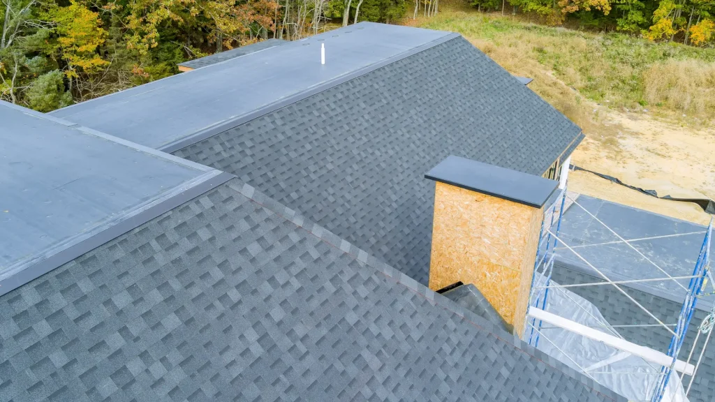 Newly installed asphalt shingle roof on a residential home surrounded by trees – Pinnacle Pro Builders.