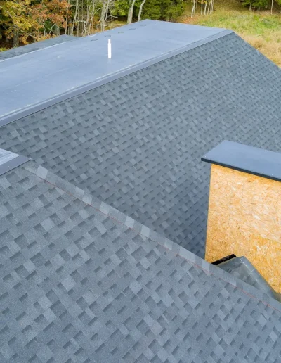 Newly installed asphalt shingle roof on a residential home surrounded by trees – Pinnacle Pro Builders.