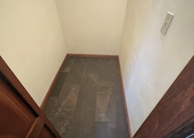 Walk-in closet with slate tile flooring and wooden trim after renovation