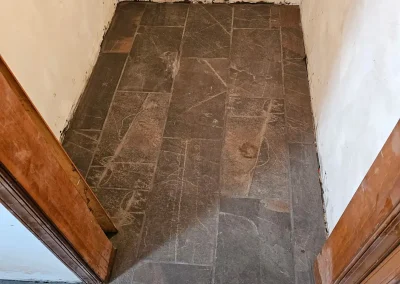 Walk-in closet with slate tile flooring and wooden trim after renovation