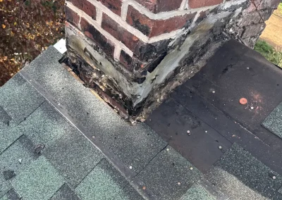 Damaged chimney flashing and deteriorated mortar on roof before repair