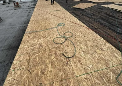 Commercial roof redecking with new plywood sheets installed for a stable, durable base before waterproof membrane application.