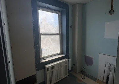 Bathroom renovation drywall installation phase with window and structural prep before tile installation