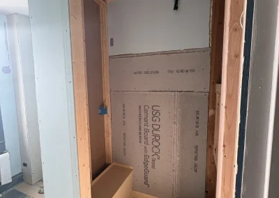 Bathroom remodel framing and cement board installation for custom walk-in shower during construction phase